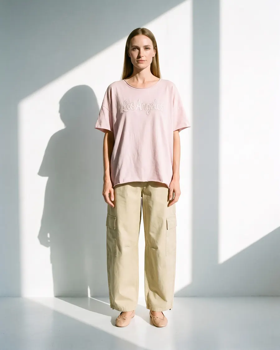 Modelo virtual con remera rosa bordada y pantalón cargo, foto 1 de 4