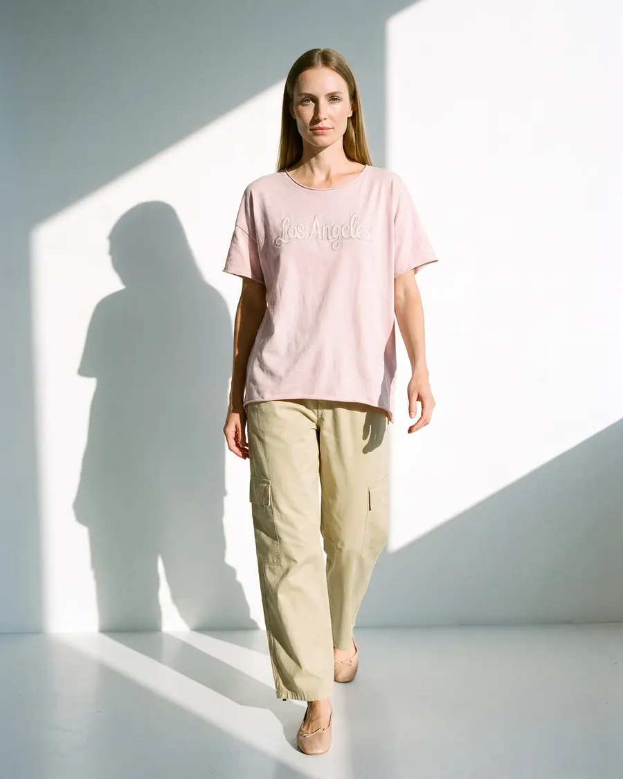 Modelo virtual con remera rosa bordada y pantalón cargo, foto 2 de 4