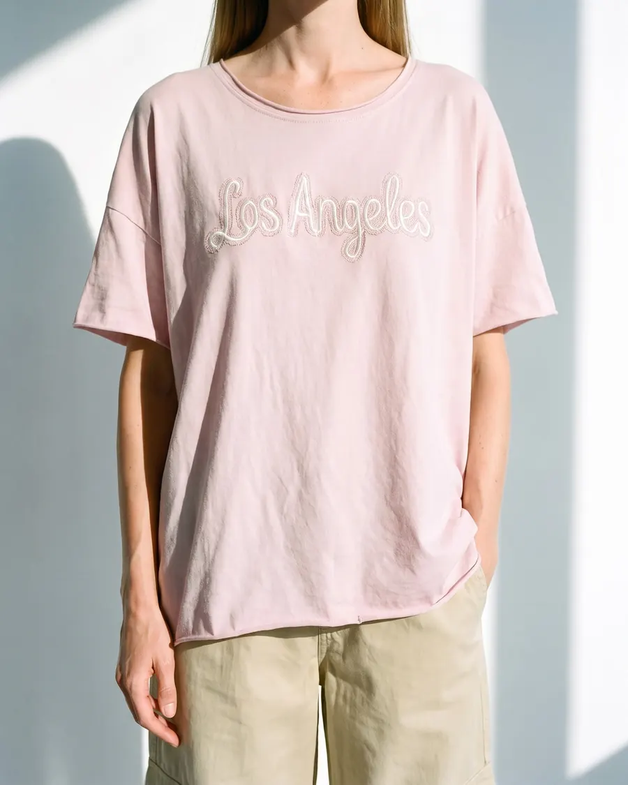 Modelo virtual con remera rosa bordada y pantalón cargo, foto 4 de 4